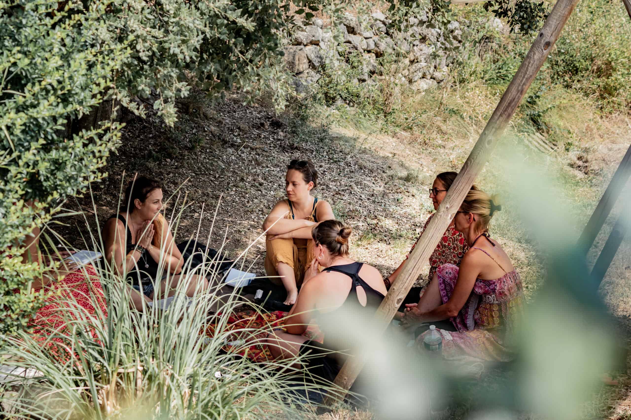femmes assises en cercles qui discutent sous un arbre