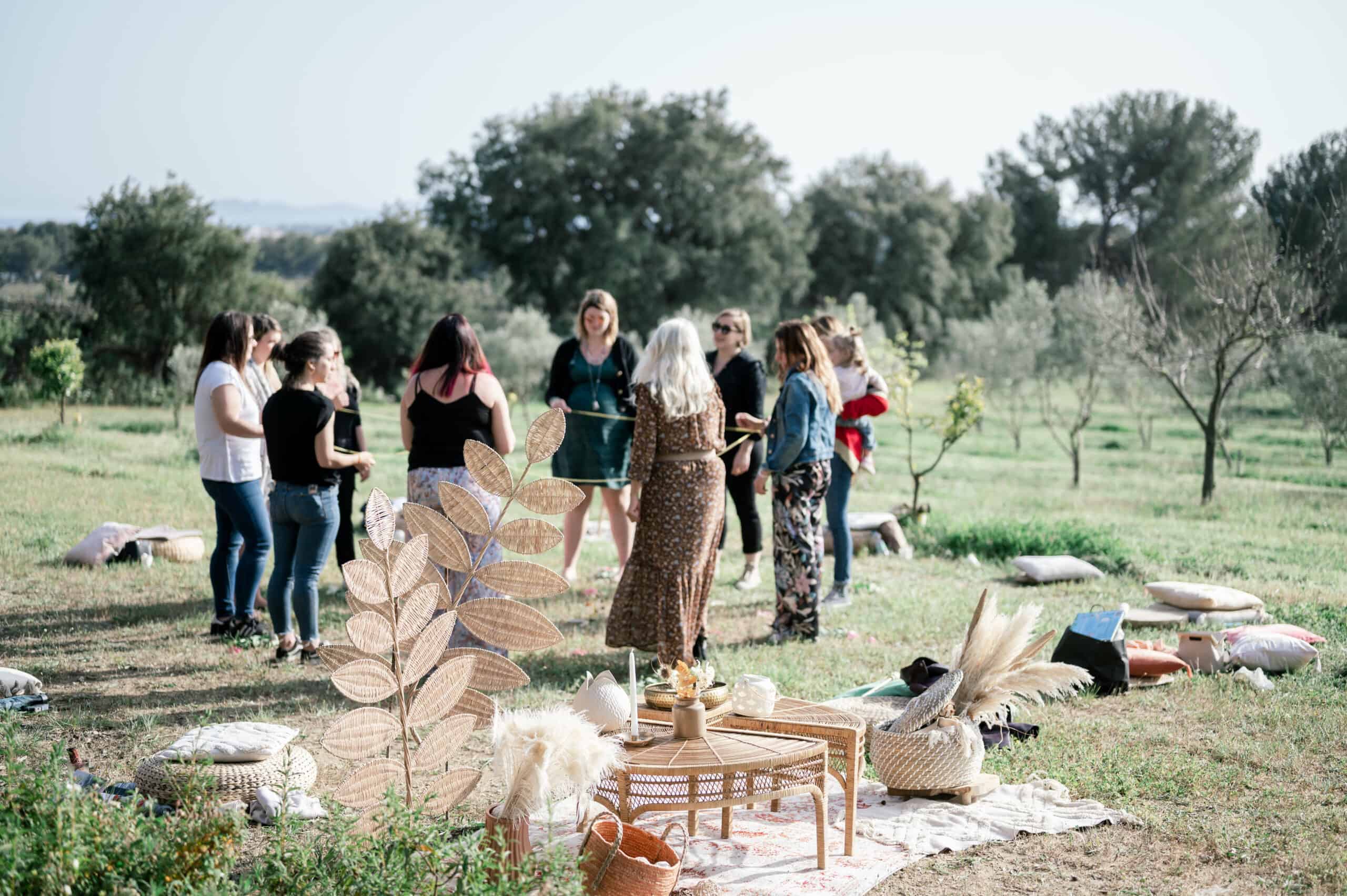 femmes dans un champ d'olivier debout en cercle relier par un ruban