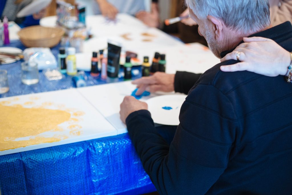 un homme qui peint lors d'un atelier d'art thérapie de la retraite holistique en famille en PACA