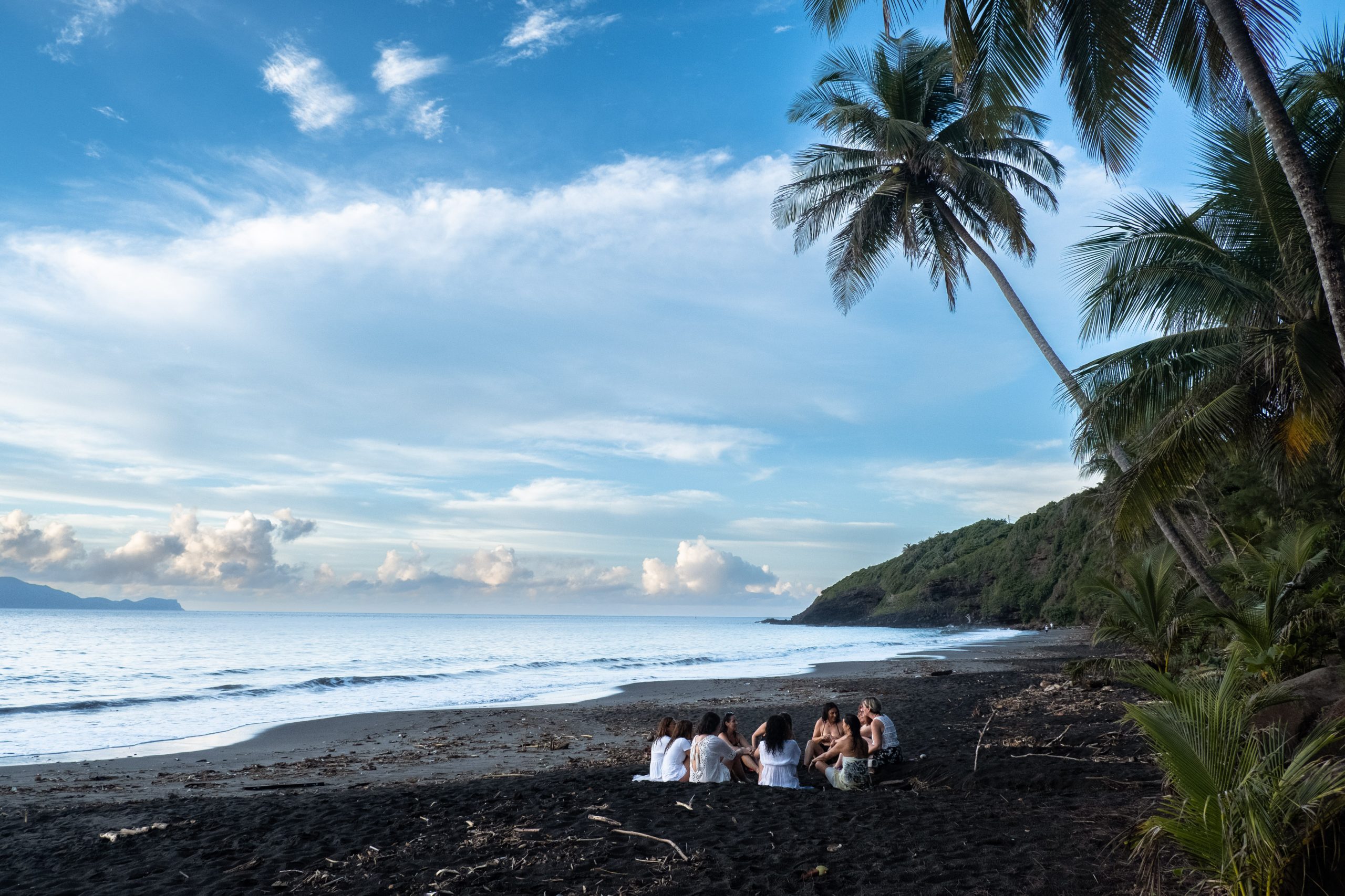 Femmes méditant sur une plage de la mer des Caraïbes lors de la retraite holistique en guadeloupe