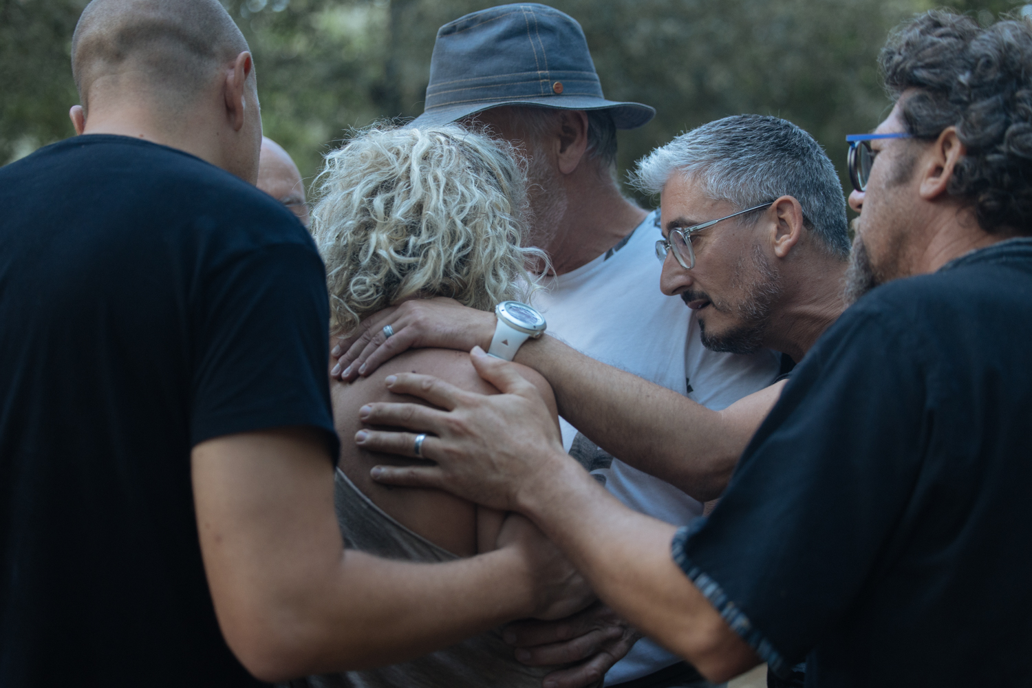 Un groupe mixte entourant une participante avec bienveillance et soutien lors d’un atelier en pleine nature, montrant l’harmonie et l’humanité dans un espace de sororité et de fraternité.
