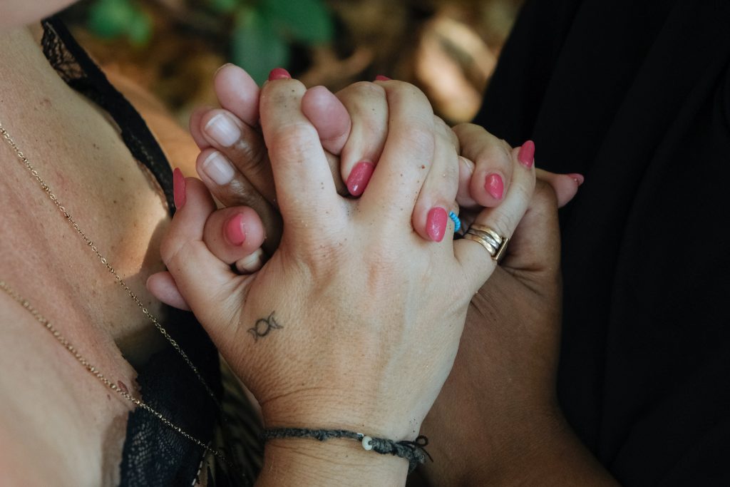 Deux femmes se tenant la main, symbolisant le soutien et la philosophie du lâcher-prise 