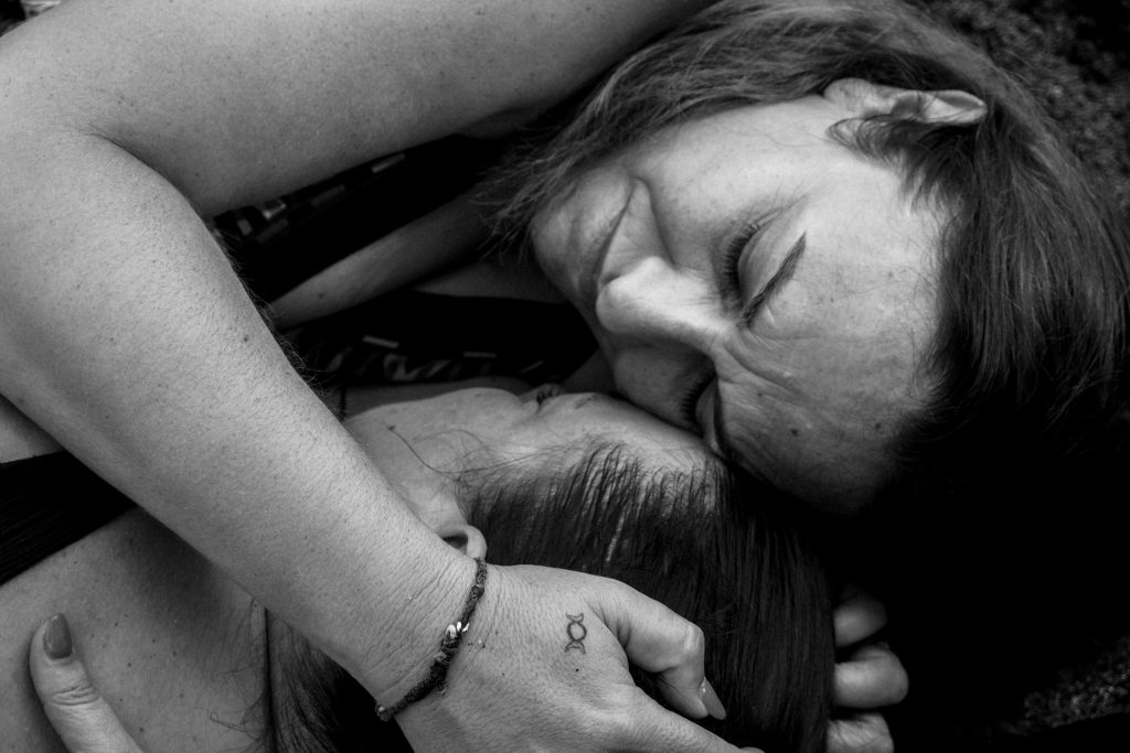 Emmanuelle consolant une femme en pleine libération émotionnelle, illustrant le soutien dans le lâcher-prise
