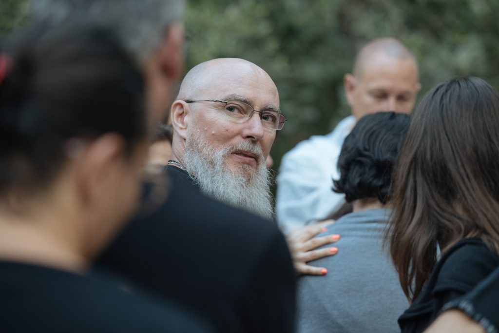 Hommes participant à un moment de partage émotionnel intense lors d'une retraite spirituelle, incarnant le développement personnel chez l'homme et la guérison émotionnelle.