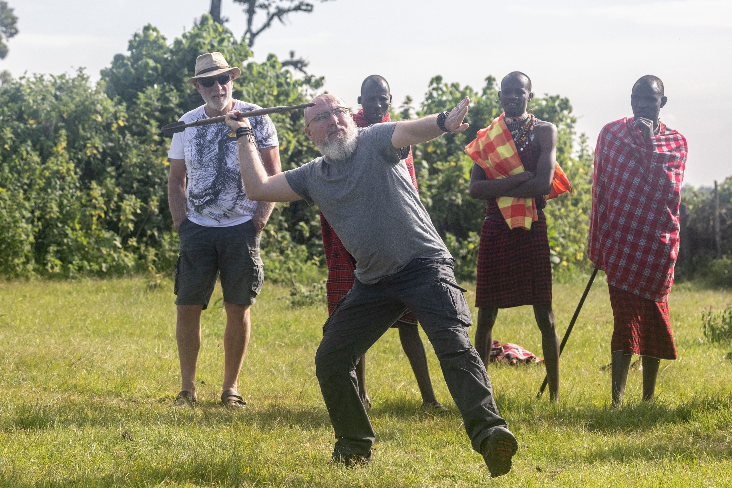 Homme participant à une activité de lancer de javelot lors d'une retraite spirituelle en Afrique, explorant le développement personnel chez l'homme à travers des traditions ancestrales.