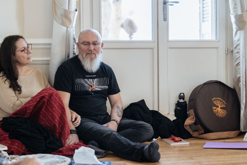 Hommes animant un atelier de développement personnel chez l'homme, favorisant l'ouverture émotionnelle et le lâcher-prise dans un cadre spirituel.