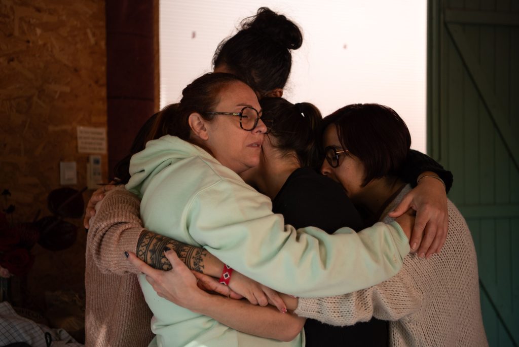 Un groupe de femmes réunies dans une étreinte chaleureuse, illustrant la sororité, la gratitude et la continuité des liens malgré les transformations de la vie.