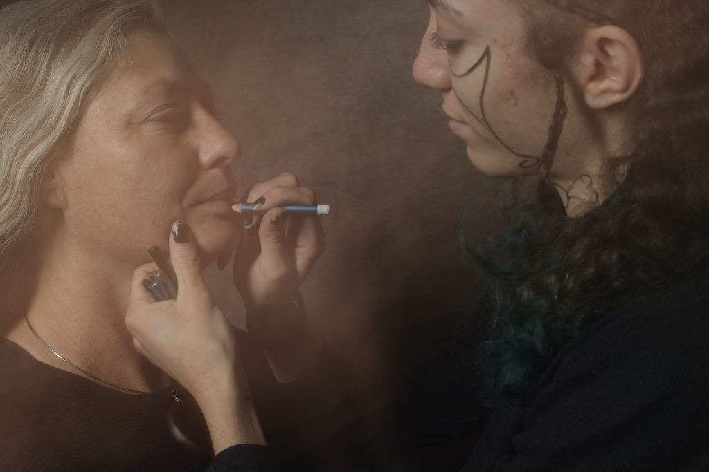 Rituel intime où un enfant maquille son parent, moment de connexion et de renforcement de la confiance en soi.