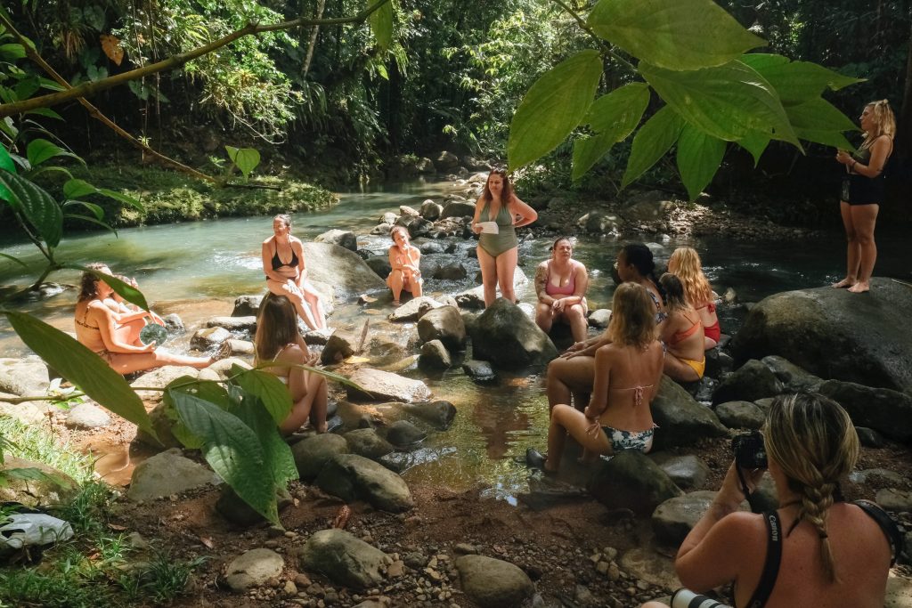 retraite-therapeutique-guadeloupe-cercles-riviere-immersion.jpg
Cercle de femmes en maillot autour d’un rocher dans une rivière tropicale en Guadeloupe, moment de partage et de guérison
