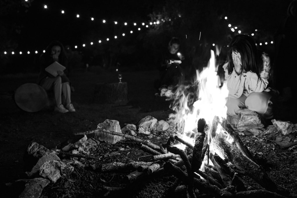 Cercle de femmes autour d’un feu lors d’une retraite pour lâcher le contrôle et libérer les émotions en profondeur.