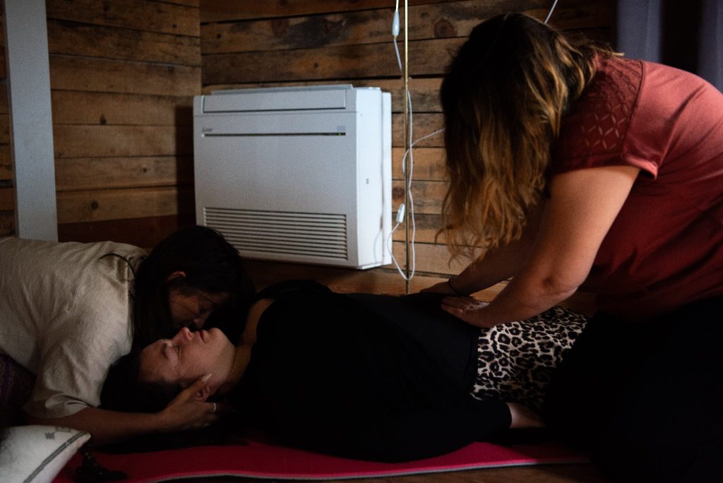 Soin thérapeutique pendant une retraite pour aider une femme à lâcher le contrôle ancré dans le corps.