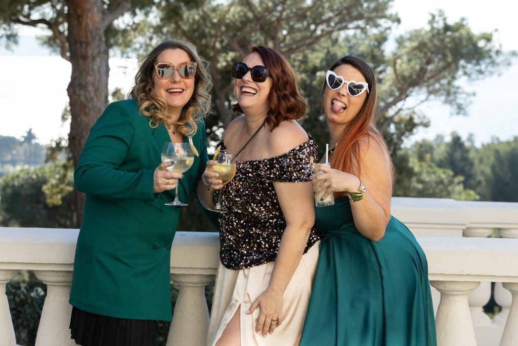 amis-rire-verres-
Trois amies rient et trinquent ensemble en extérieur, symbole d’amitié, de joie et de communication authentique.