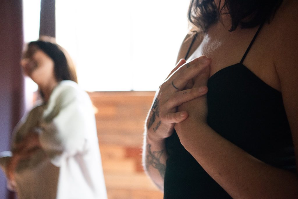 Femme posant ses mains sur son cœur lors d’un cercle de parole, illustration de vivre avec l’hypersensibilité dans un espace sécurisé.