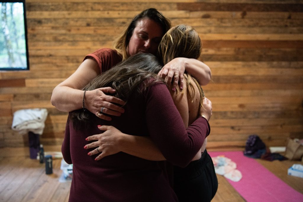Câlin collectif entre femmes dans un espace thérapeutique bienveillant, pour illustrer la cohabitation douce avec l’hypersensibilité.
