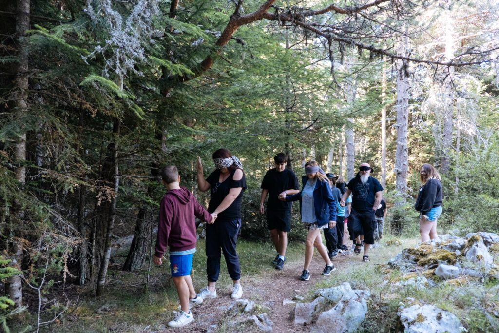 Exercice de confiance les yeux bandés en forêt, activité de la retraite Terre de Tribu pour développer la confiance en soi à l’adolescence.