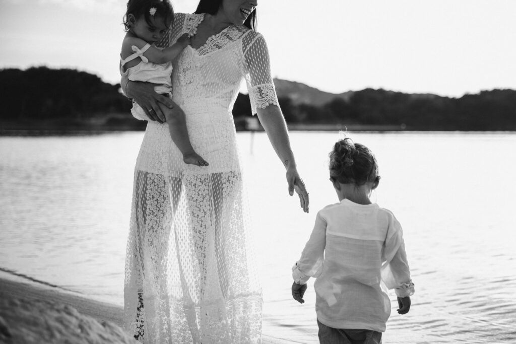 Maman solo entrepreneur : le parcours inspirant de Johanna, fondatrice de Baby Événement 1 Maman solo entrepreneur au bord de l’eau avec ses enfants, scène en noir et blanc illustrant la maternité, la présence et la transmission.