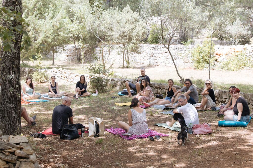 La fatigue existentielle : cette fatigue qu’aucune nuit de sommeil ne répare 1 Cercle de participants assis en pleine nature lors d’une retraite, espace de partage et de pause pour sortir du rythme quotidien et apaiser la fatigue existentielle