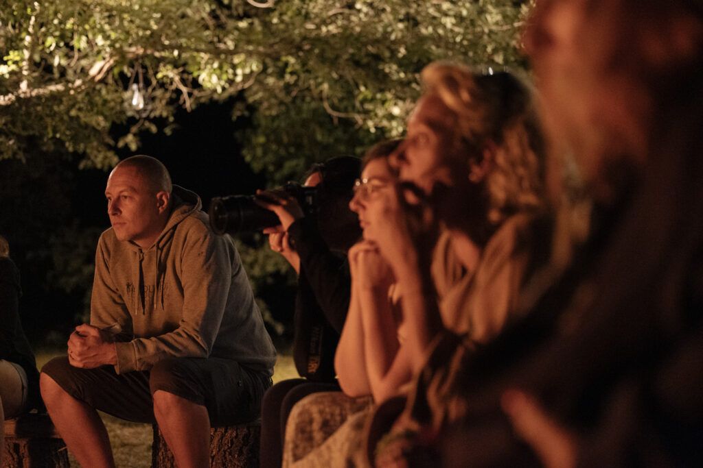 Temps de cercle et d’écoute autour du feu lors d’une retraite, espace sécurisant pour déposer la fatigue mentale et retrouver du sens.