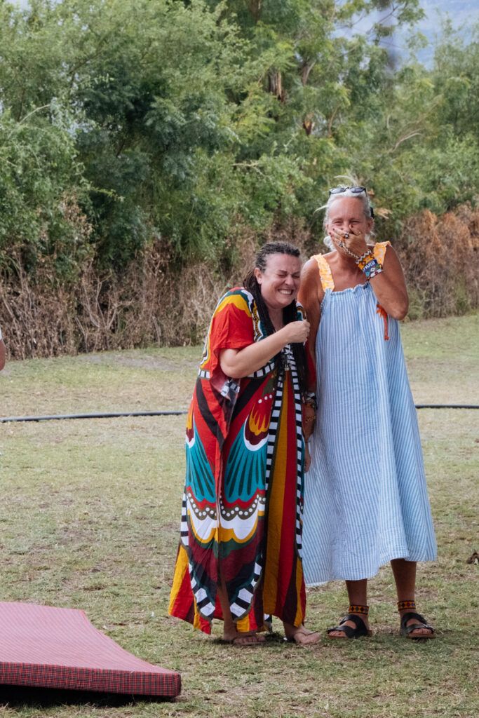 Deux femmes entrepreneures riant ensemble lors d’une retraite en Afrique organisée par Emmanuelle Guiard-Paulos, illustrant l’esprit de communauté dans l’entrepreneuriat au féminin.