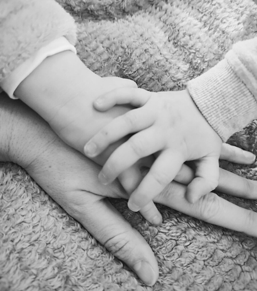 Entreprendre en tant que femme et maman : le parcours de Cindy, entre liberté, passion et équilibre de vie 1 Mains d’un enfant posées sur celles d’un adulte symbolisant le lien entre maternité et entrepreneuriat chez une femme