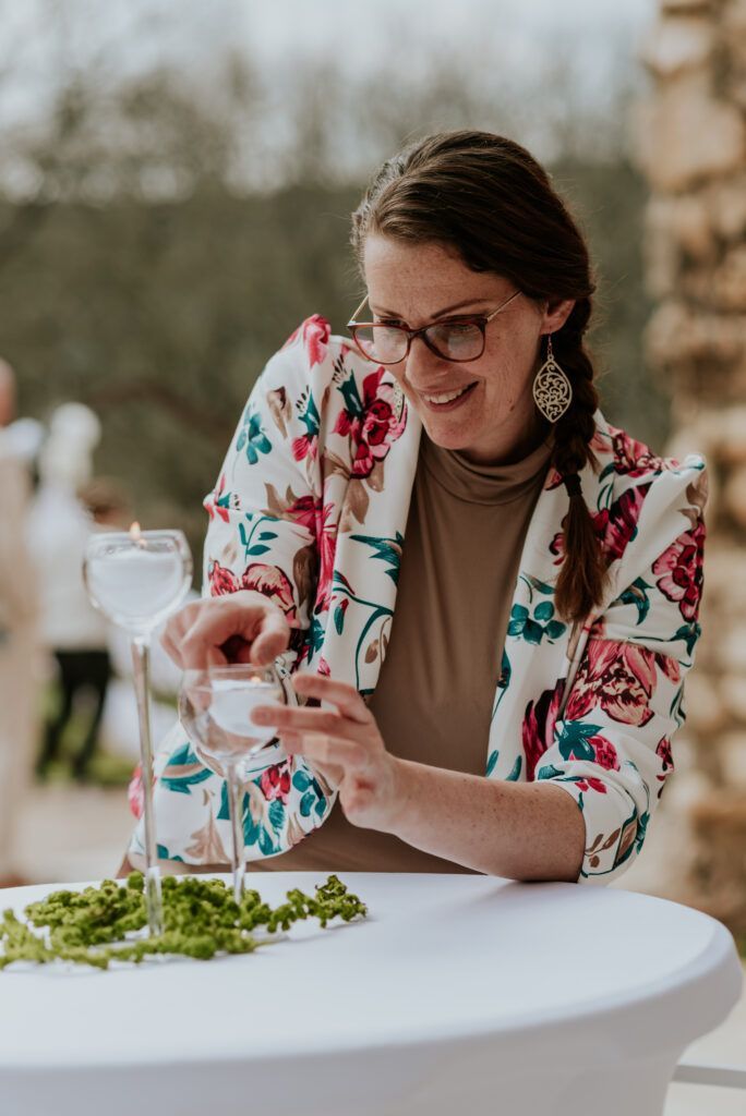 Entreprendre en tant que femme et maman : le parcours de Cindy, entre liberté, passion et équilibre de vie 2 Femme entrepreneure ajustant une bougie lors d’une décoration de mariage raffinée en extérieur