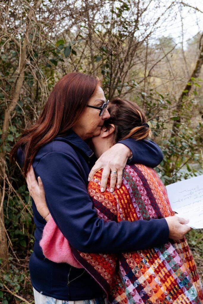 Quand la maladie entre dans une famille : ce que l’on ne voit presque jamais 2 Mère et fille s’enlaçant avec émotion pendant une retraite famille en nature après avoir partagé leurs ressentis sur l’impact de la maladie dans une famille.