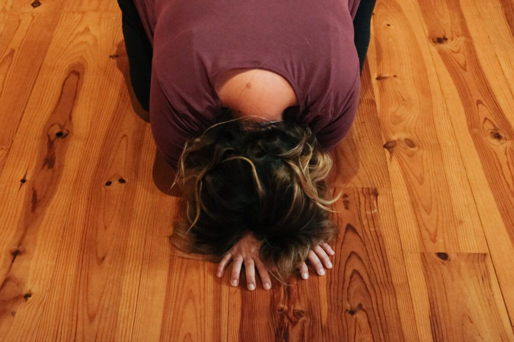 Développer notre intelligence émotionnelle : la solution pour sauver la vie ? 4 Personne en posture introspective au sol pendant un rituel de connexion à soi pour développer son intelligence émotionnelle