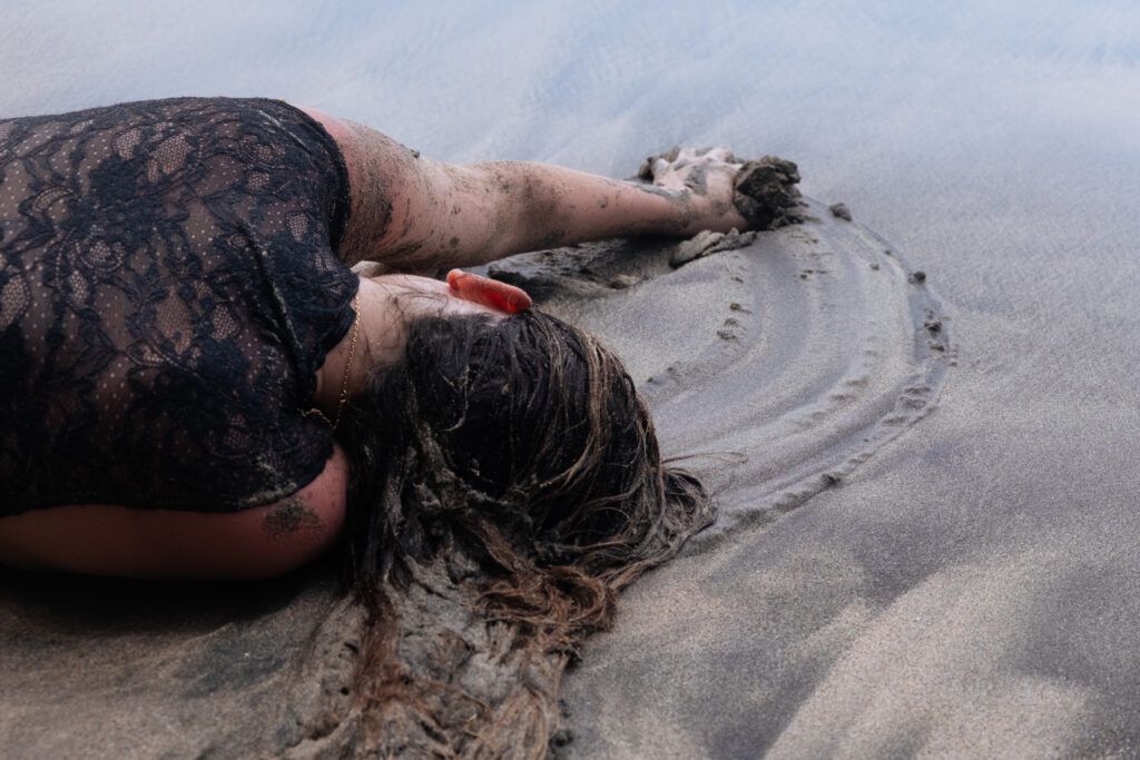 Femme allongée dans le sable laissant une empreinte, symbolisant le lâcher-prise et la liberté personnelle