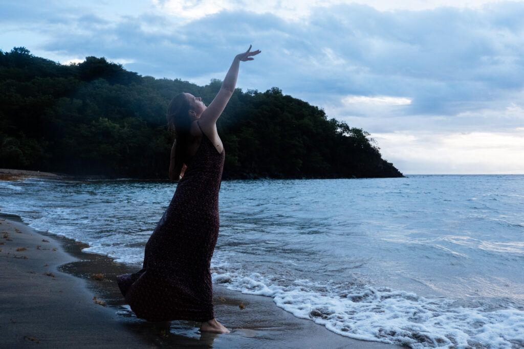 Femme face à la mer en mouvement, incarnant la liberté personnelle, la connexion à la nature et l’expression de soi