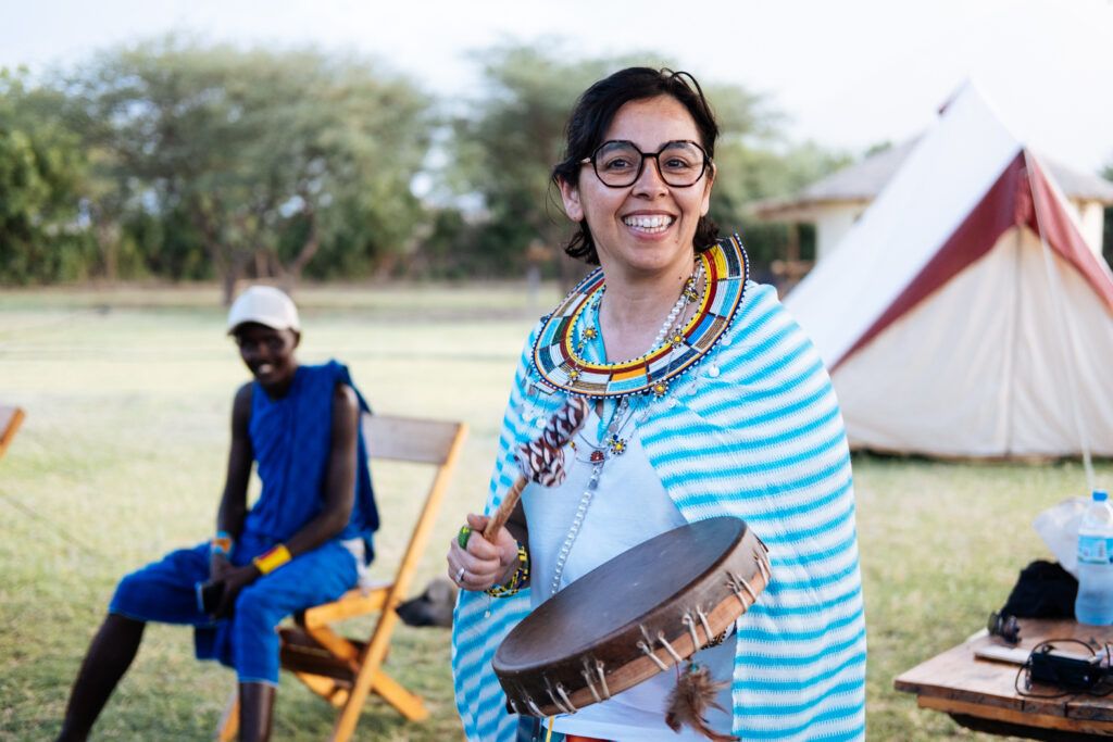 Audrey jouant du tambour pendant une immersion culturelle et humaine lors de la retraite initiatique en Afrique HUMAN.