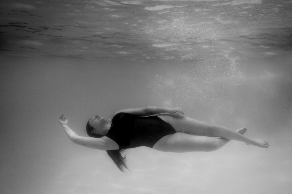 Toujours disponible pour les autres : quand la relation devient à sens unique 4 Femme allongée et apaisée sous l’eau, illustrant le lâcher-prise et la reconnexion à soi.