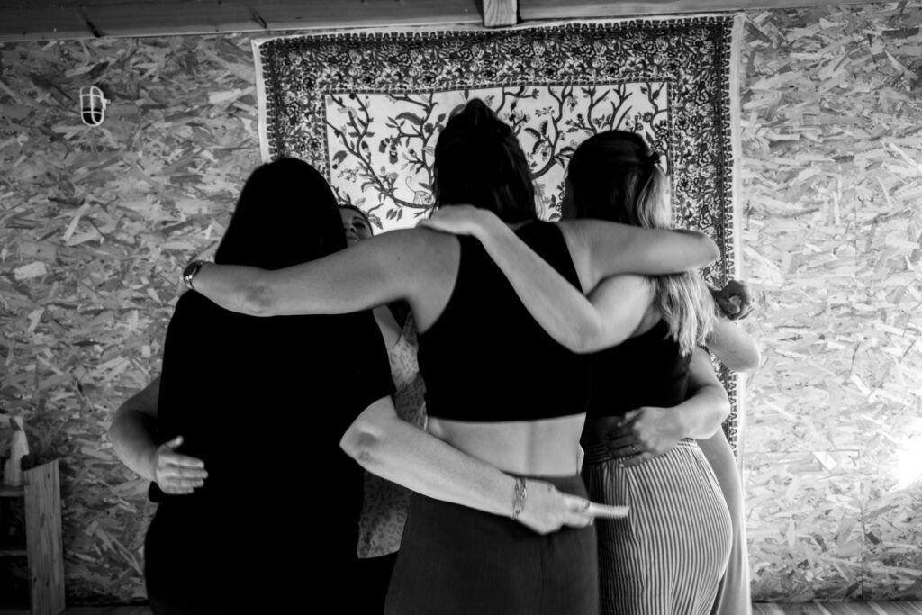 Des femmes réunies dans une étreinte collective lors d’une retraite thérapeutique